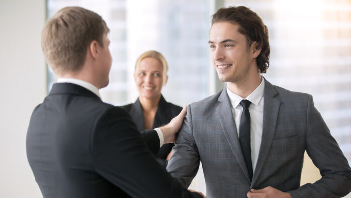 Boss,Promoting,Male,Subordinate.,Two,Businessmen,Handshaking,,Congratulating,On,Promotion,